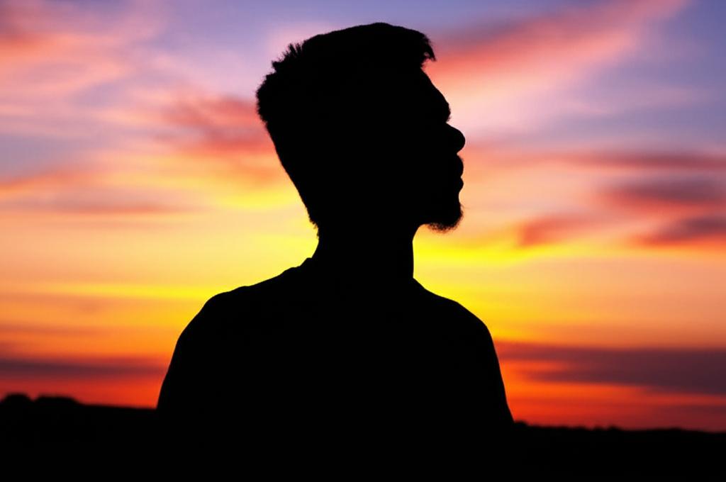 man looking thoughtful or slightly worried, sunset, silhouette, pensive mood