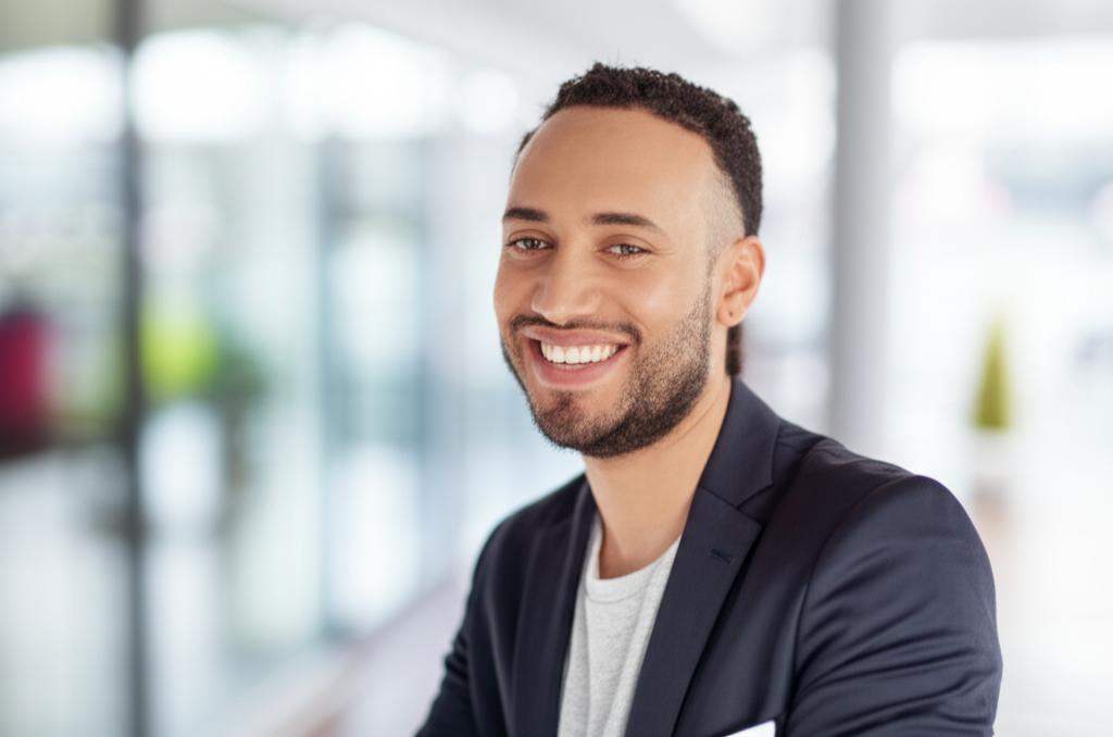 man smiling confidently, blurred background, positive energy